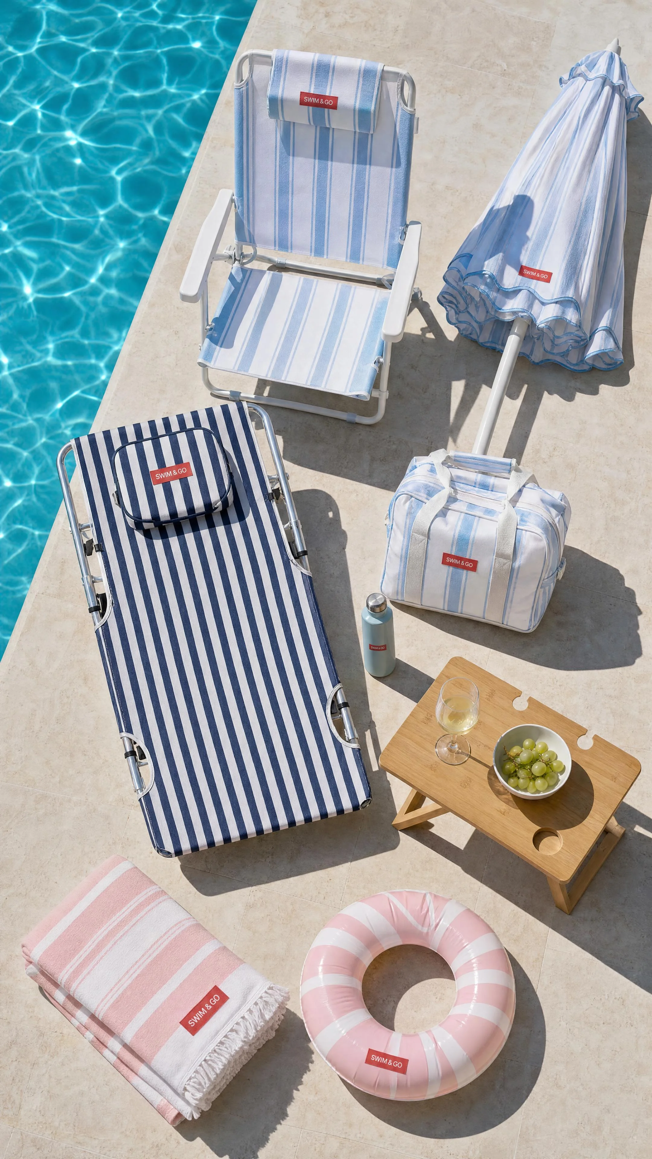SWIM & GO poolside accessories arranged in a sunlit overhead composition