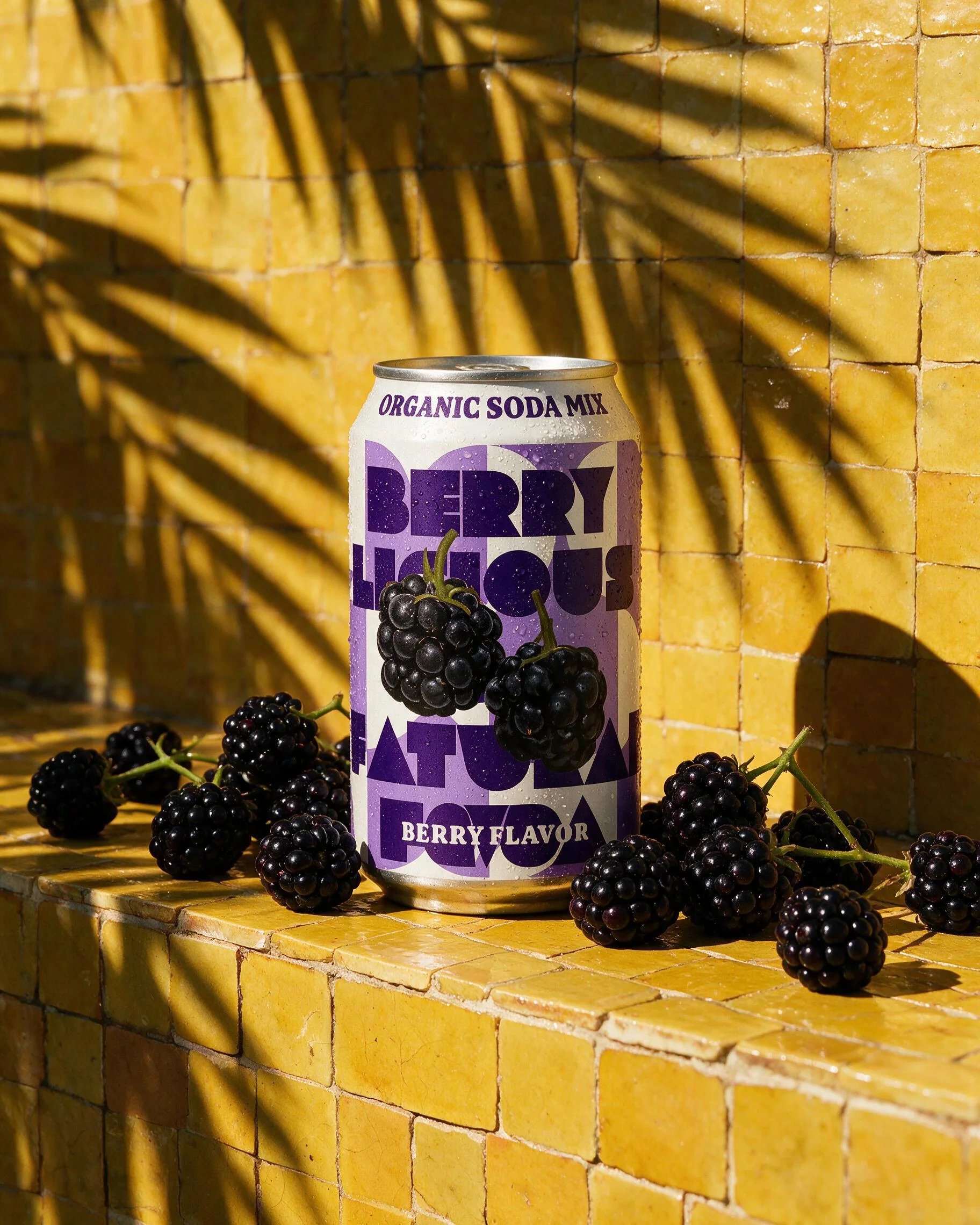 Mixed berry photoshoot: can with berries on a yellow plinth