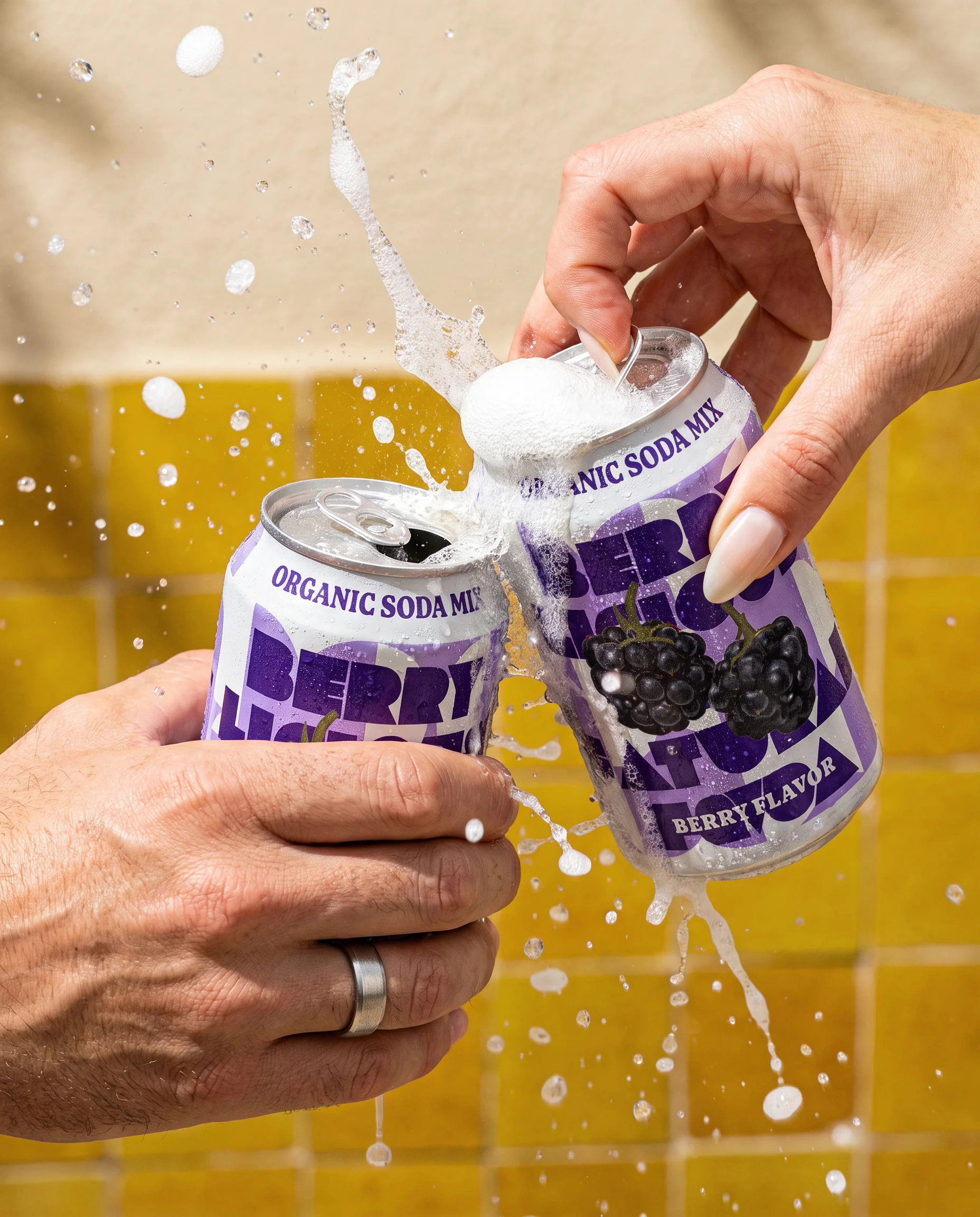 Mixed berry photoshoot: two cans raised in a toast